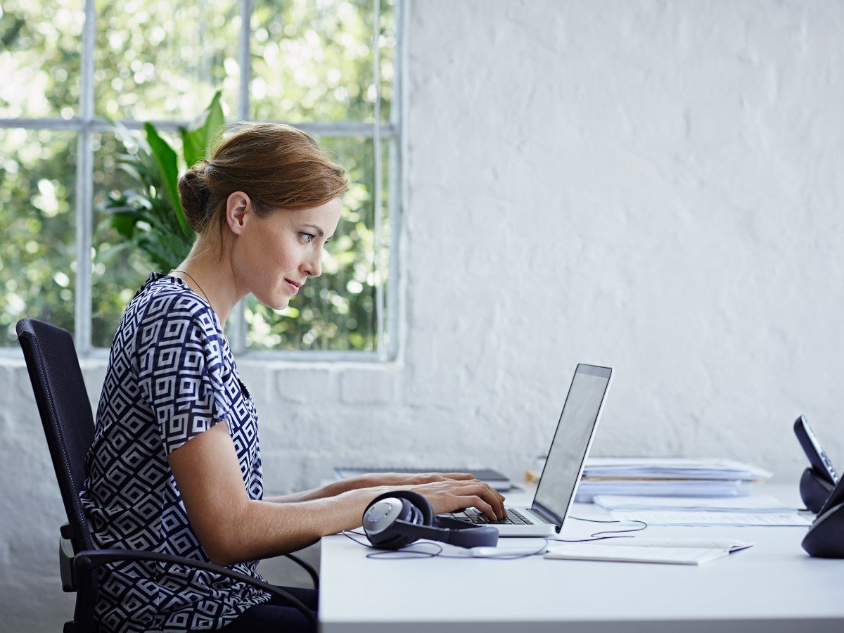 Woman sitting at desk in front of laptop
